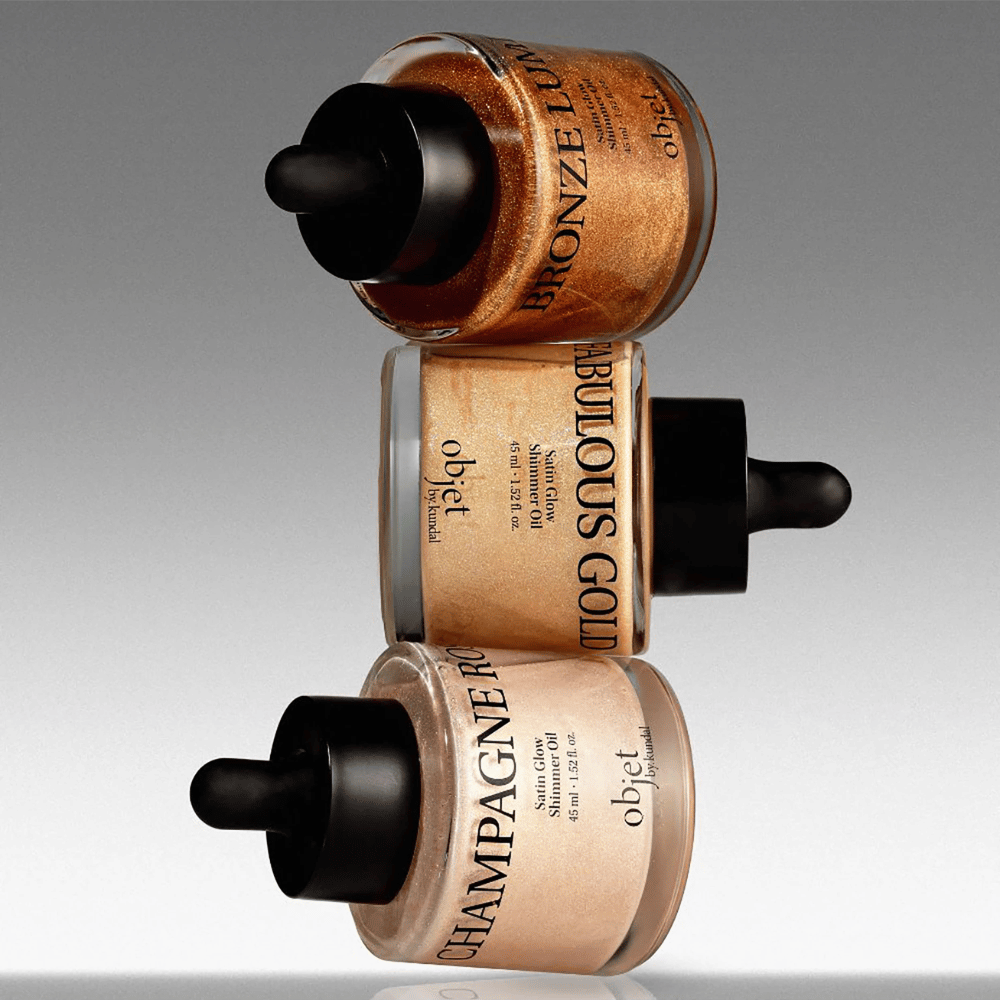 Objet by KUNDAL Satin Glow Shimmer Oil en Bronze Lumière, Fabulous Gold et Champagne Rose – huiles corporelles scintillantes à la finition illuminatrice.