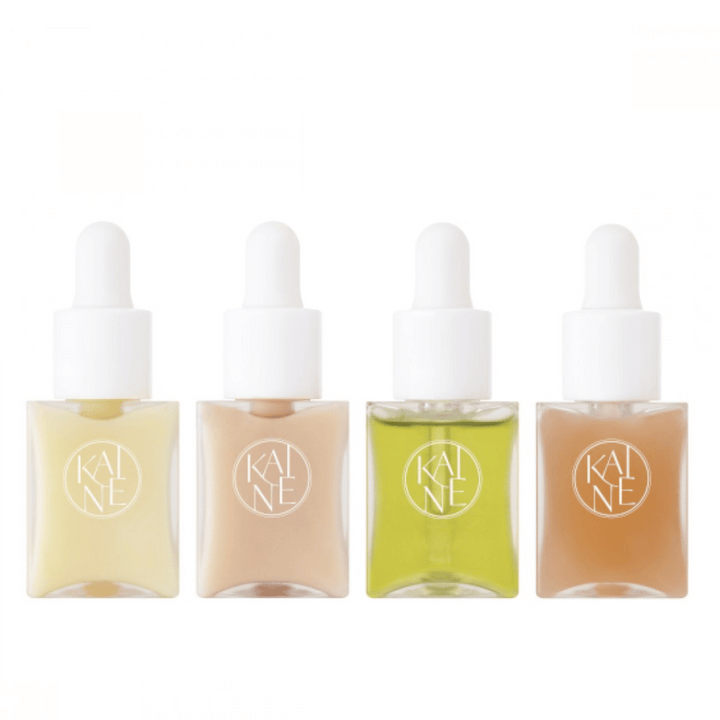 Quatre flacons de sérum colorés de KAINÉ Serum Discovery Kit avec bouchon pipette, conçus pour répondre à différents besoins de la peau dans un emballage minimaliste et élégant.