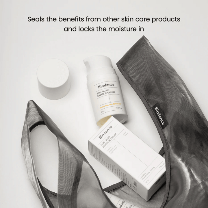 Biodance Skin-Glow Essence Cream en focus avec l'emballage du produit et une trousse transparente noire, avec un texte au-dessus soulignant la capacité de la crème à emprisonner l'humidité et à renforcer l'effet des autres produits de soin de la peau.