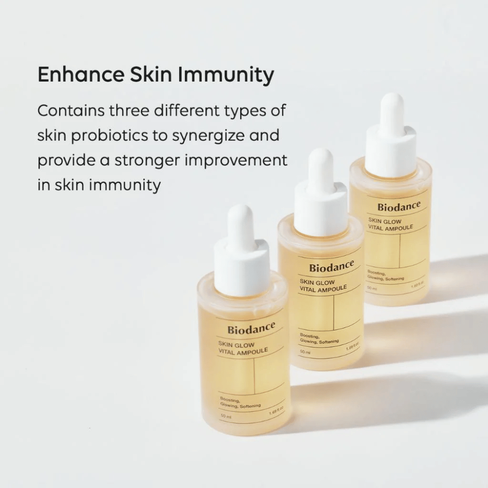 Trois flacons de Biodance Skin Glow Vital Ampoule sont présentés avec le texte 'Enhance Skin Immunity'. Le produit contient trois types différents de probiotiques cutanés qui renforcent l'immunité de la peau et améliorent sa protection.