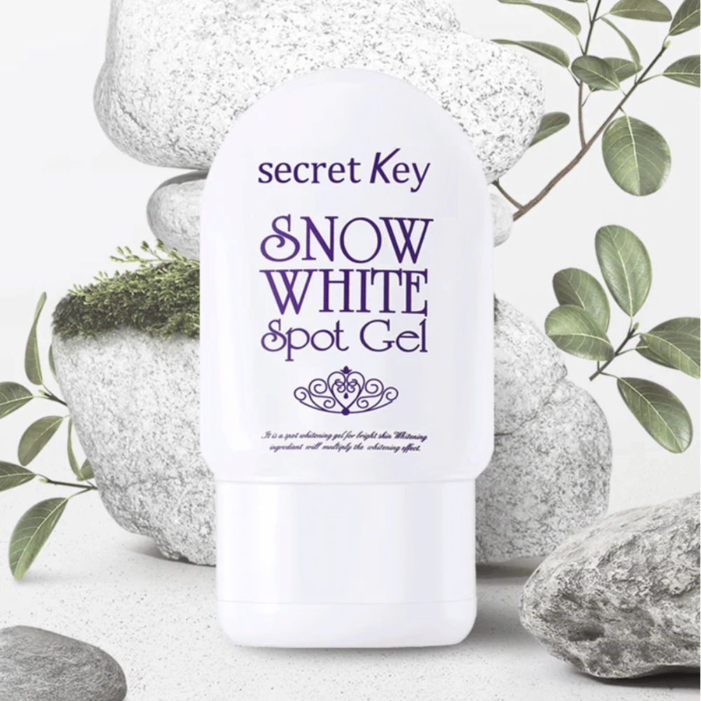 Secret Key Snow White Spot Gel photographié contre des pierres et des feuilles vertes.