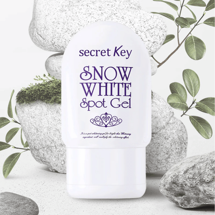 Secret Key Snow White Spot Gel photographié contre des pierres et des feuilles vertes.