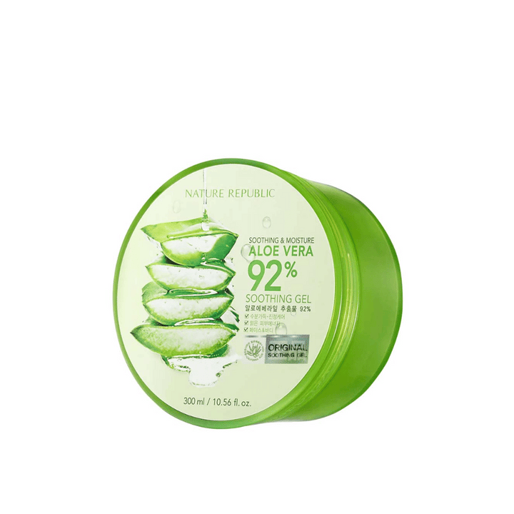 Une boîte ronde verte avec Nature Republic Aloe Vera 92% Gel Apaisant. L'emballage montre une image de feuilles d'aloe vera et un texte décrivant les propriétés apaisantes et hydratantes du produit. Le contenu est de 300 ml (10.56 fl. oz).