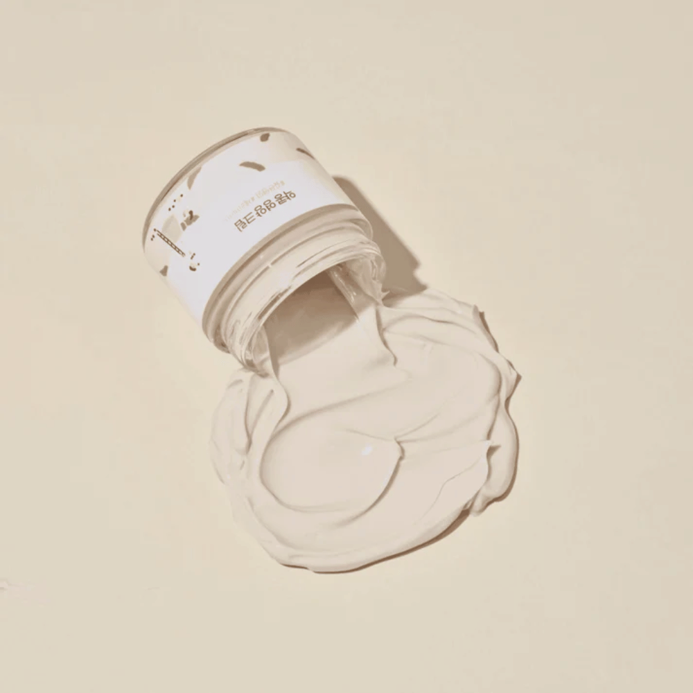 Mixsoon Soybean Nourishing Cream renversée du pot sur un fond beige. La consistance riche de la crème montre ses propriétés hydratantes intenses.