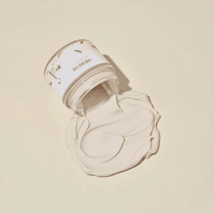Mixsoon Soybean Nourishing Cream renversée du pot sur un fond beige. La consistance riche de la crème montre ses propriétés hydratantes intenses.