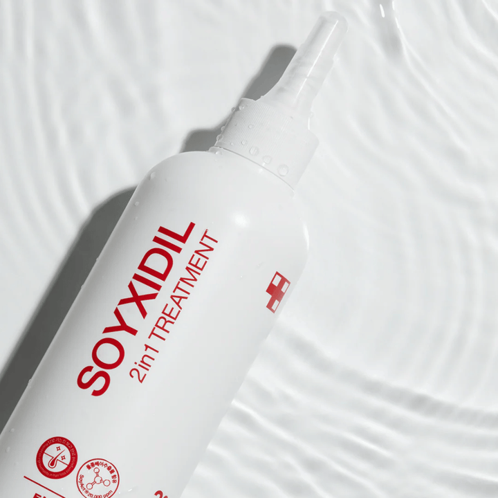 Bouteille de Medicube Soyxidil 2in1 Treatment posée sur une surface d'eau ondulante, symbolisant des soins hydratants et rafraîchissants.