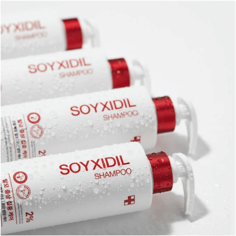 Plusieurs bouteilles de Medicube Soyxidil Shampoo alignées avec des gouttes d'eau – montrent la sensation fraîche et nourrissante du produit.