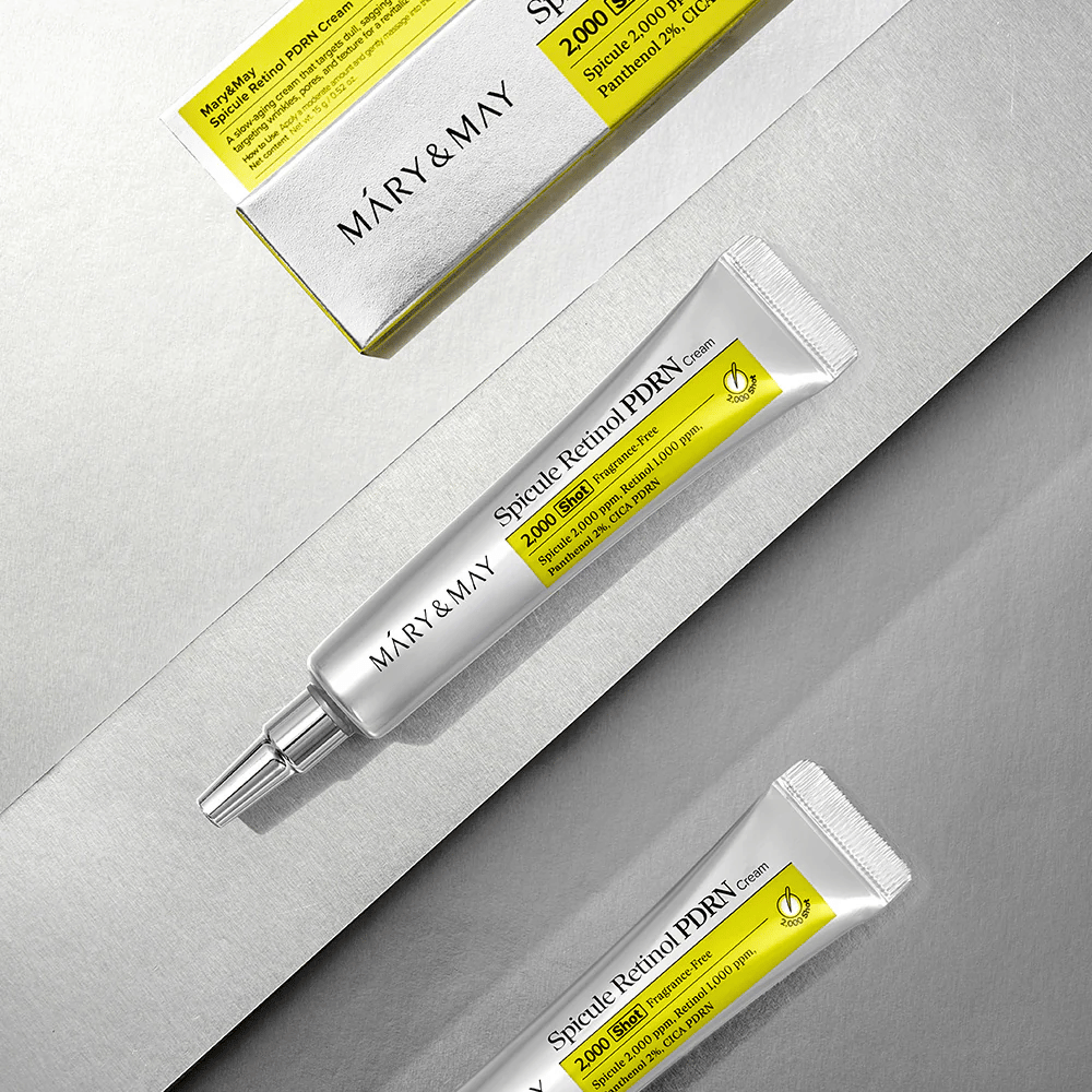 MARY & MAY Spicule Retinol PDRN Cream en tube et emballage sur fond clair, une crème pour le visage active avec rétinol, technologie de spicule et PDRN pour une amélioration de la structure de la peau et du renouvellement de la peau.