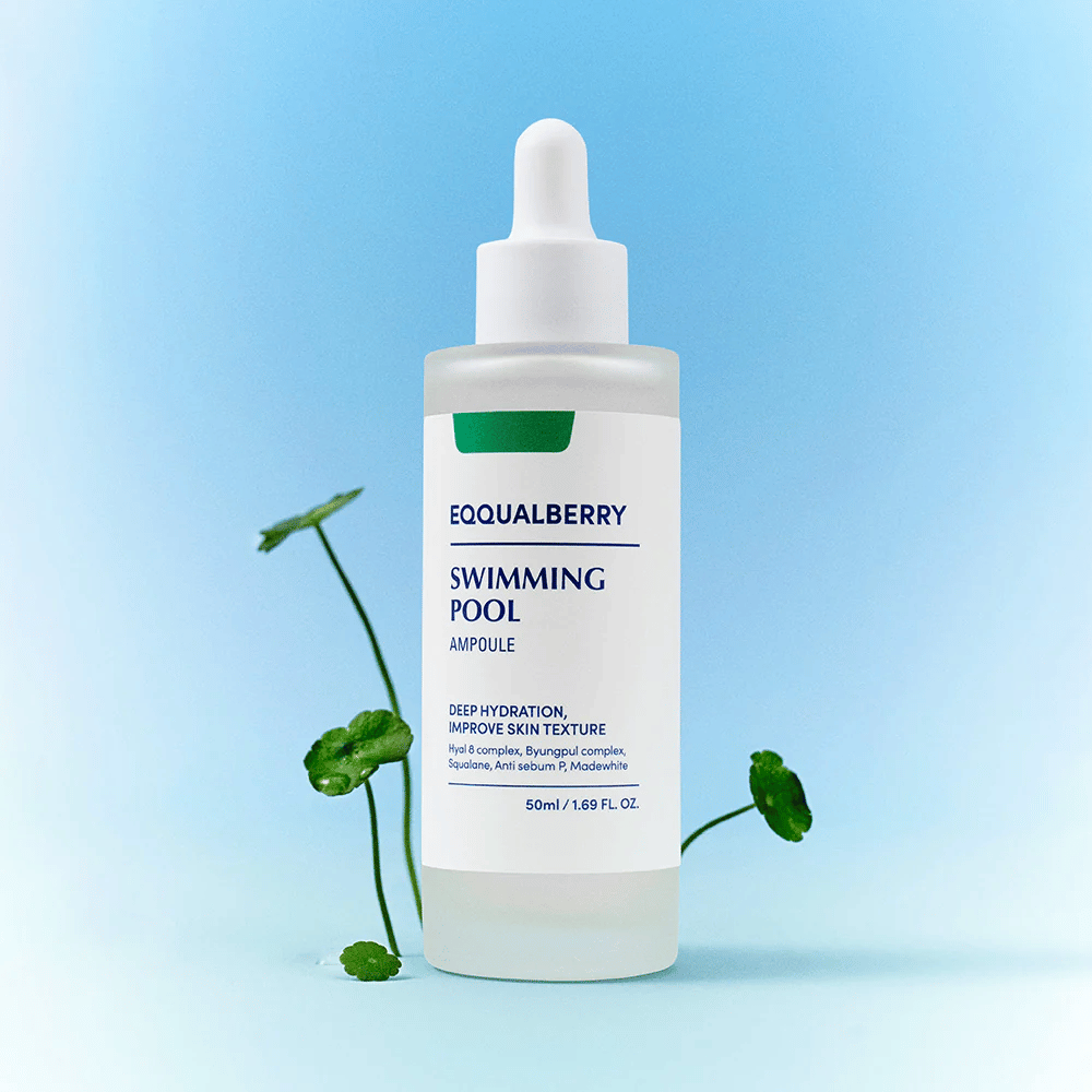 Bouteille avec Eqqualberry Swimming Pool Ampoule, un produit de soin pour une hydratation profonde et une amélioration de la structure de la peau, placé sur un fond bleu clair avec quelques plantes vertes au premier plan.