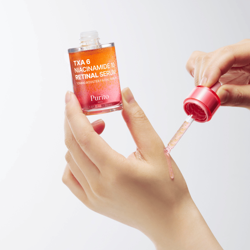 Main appliquant Purito TXA 6 Niacinamide 10 Retinal Serum. Formule légère avec des ingrédients actifs pour éclat, élasticité et peau plus claire.