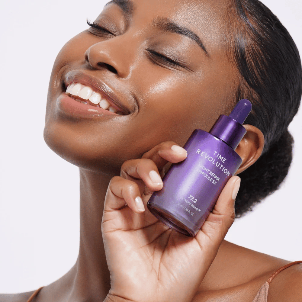 4. MISSHA Time Revolution Night Repair Ampoule 5X – modèle tenant un sérum de nuit violet pour le soin du visage et l’éclat