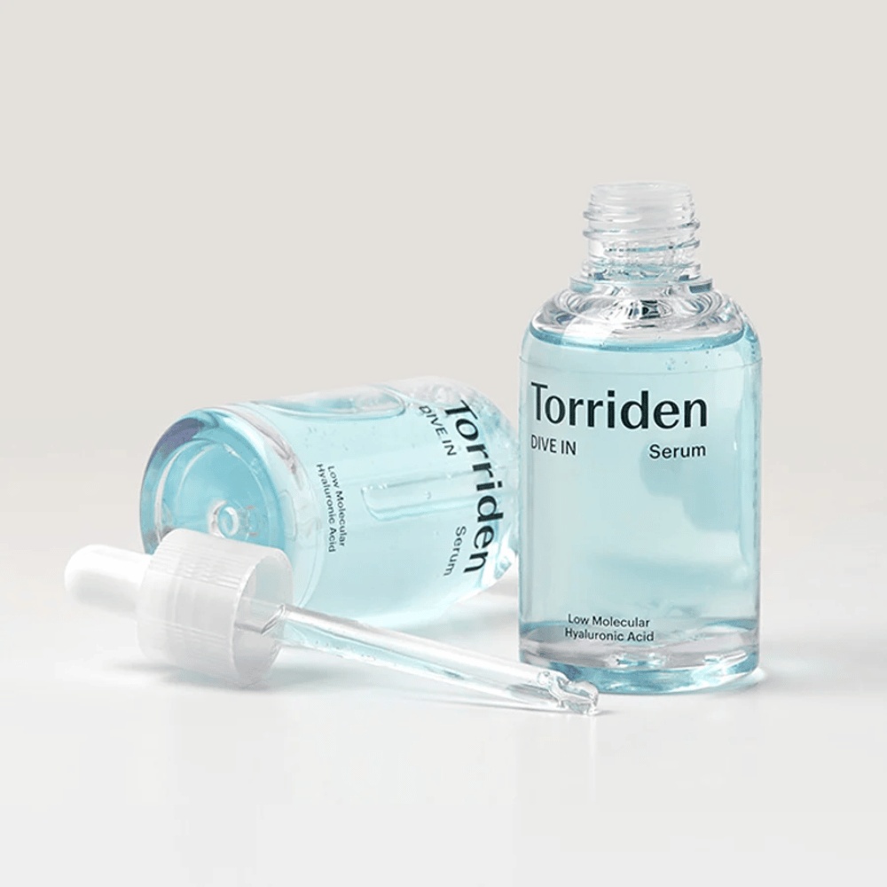 Une bouteille de Torridens DIVE-IN Low Molecule Hyaluronic Acid Serum 50ml à côté d'une bouteille d'eau, mettant en avant le sérum à l'acide hyaluronique et l'hydratation.