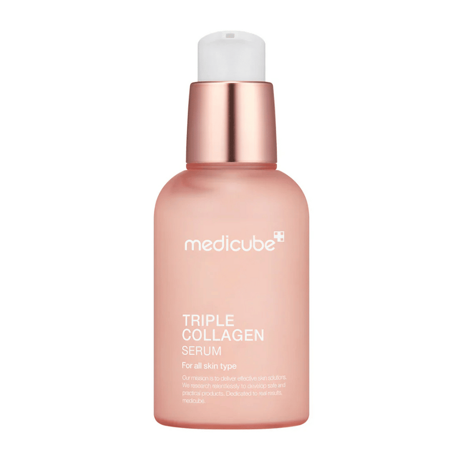 Une bouteille rose de Medicube Triple Collagen Serum, conçue pour tous les types de peau. La bouteille en verre lisse et givrée avec un bouchon rose métallique et une pompe blanche donne un look élégant, et le texte met en valeur la formule triple collagène du sérum.