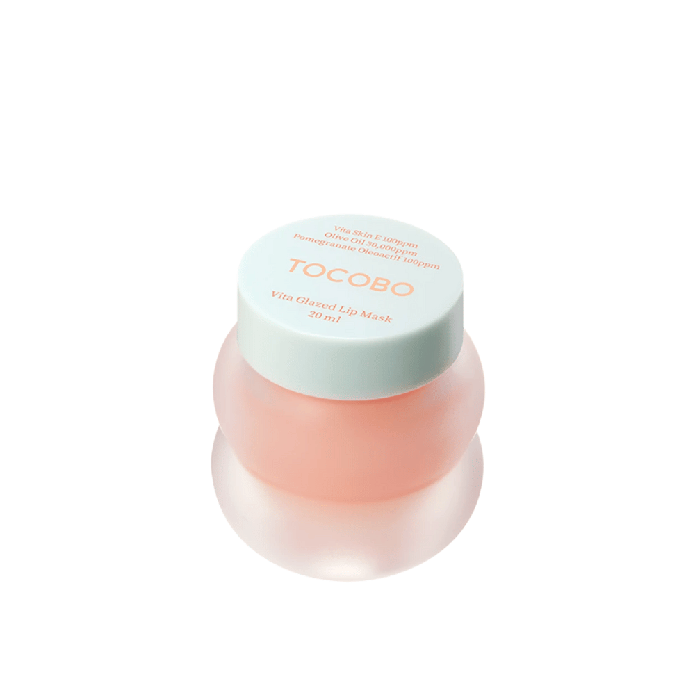 Un pot avec "Vita Glazed Lip Mask" de Tocobo est présenté. Le pot est rond et transparent avec un couvercle turquoise clair. Le masque à l'intérieur est légèrement rose et conçu pour hydrater et nourrir les lèvres. Le produit a un volume de 20 ml.