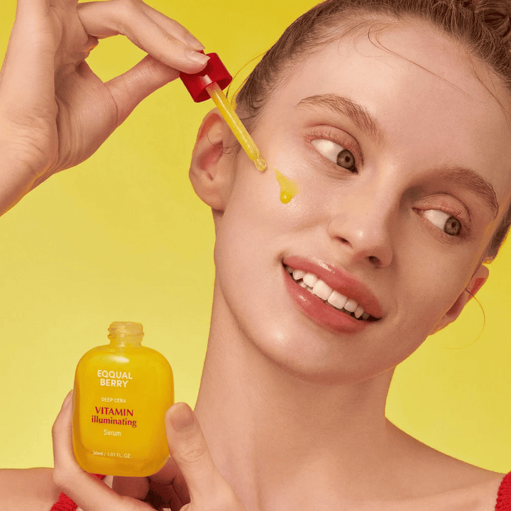 Femme souriante appliquant Equal Berry Vitamin Illuminating Serum avec une pipette. Peau fraîche et éclatante sur un fond jaune vif qui correspond à la couleur du sérum.