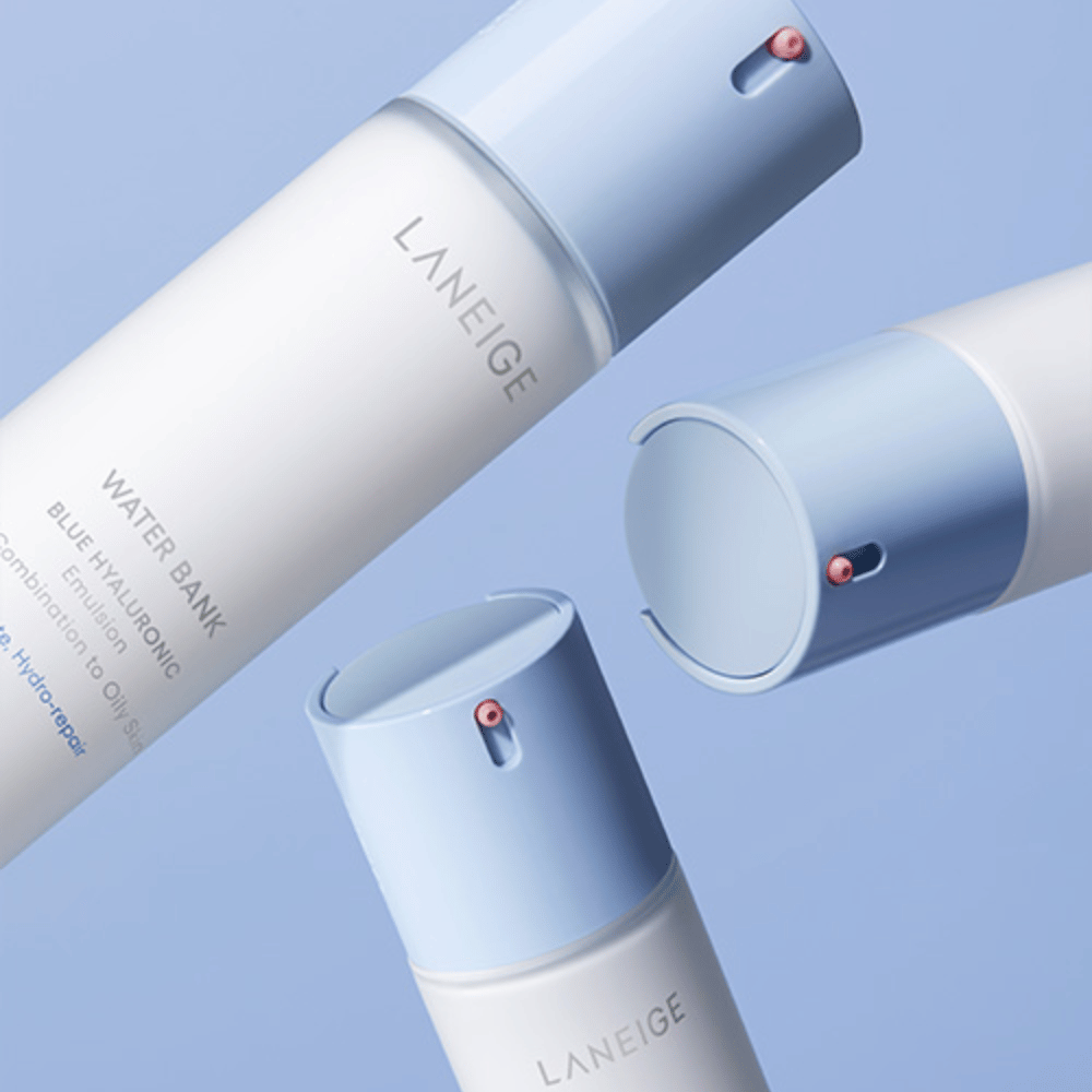 Trois bouteilles de LANEIGE Water Bank Blue Hyaluronic Emulsion avec des têtes de pompe bleu clair sur un fond bleu, montrées sous différents angles.