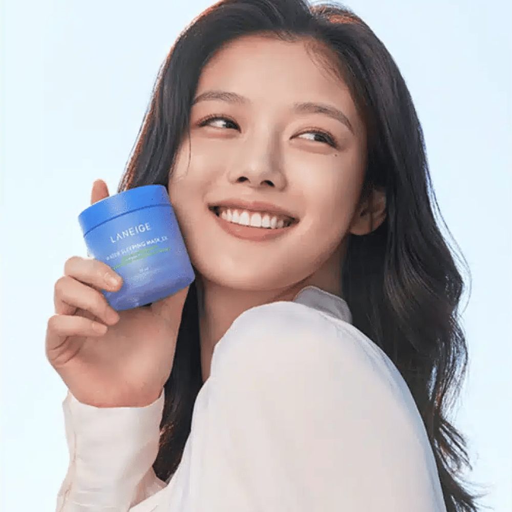 Femme souriante tenant un pot bleu de LANEIGE Water Sleeping Mask devant un fond bleu clair.
