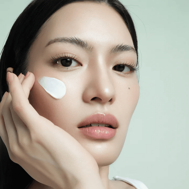 Un modèle applique d’Alba Waterfull Mild Sun Cream SPF 50+ sur le visage. Protection solaire légère et hydratante avec filtre minéral, parfaite pour un usage quotidien et les peaux sensibles.