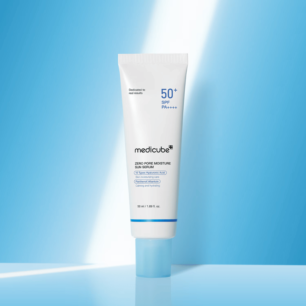 Medicube Zero Pore Moisture Sun Serum SPF50+ PA++++ présenté sur un fond bleu. Sérum solaire hydratant avec acide hyaluronique, panthénol et allantoïne pour une protection UV quotidienne et le soin de la peau.