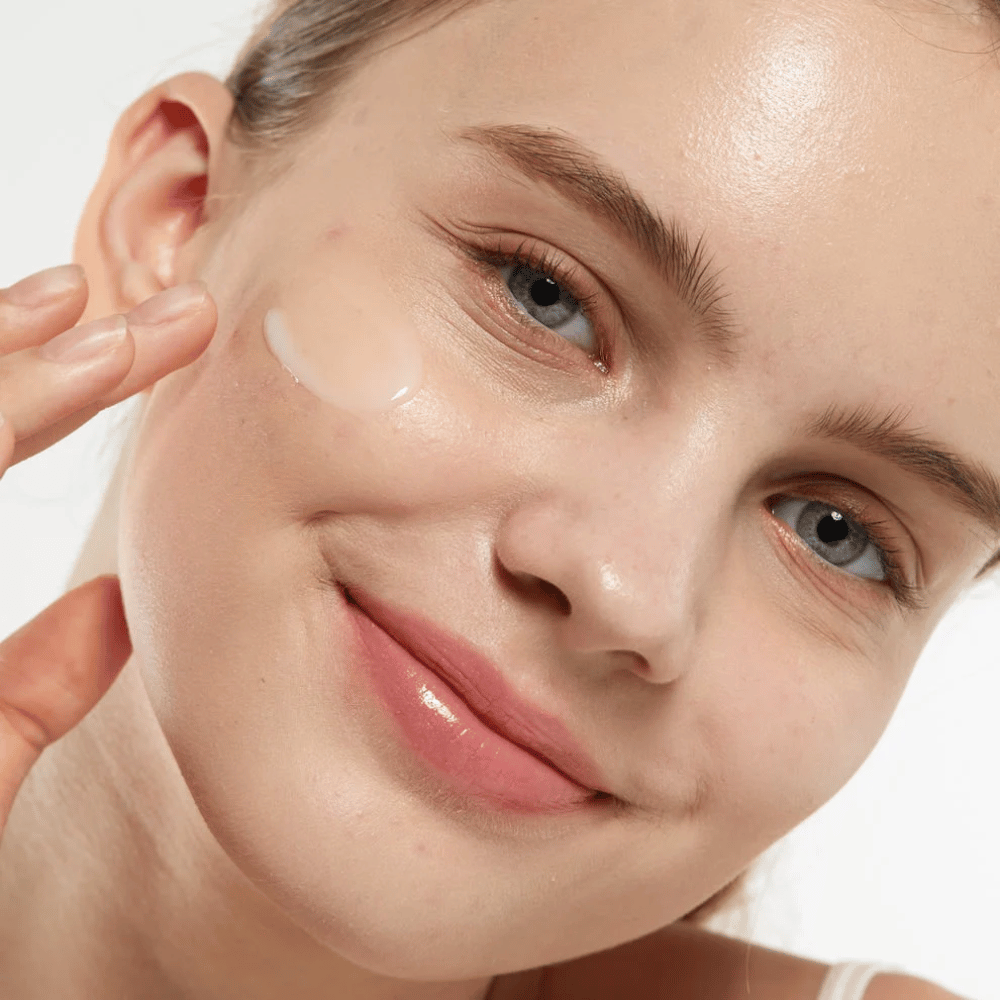 Modèle appliquant Medicube Zero Pore Serum 2.0 sur la joue, un sérum affinant les pores qui offre une texture de peau plus uniforme, une hydratation et un éclat naturel.