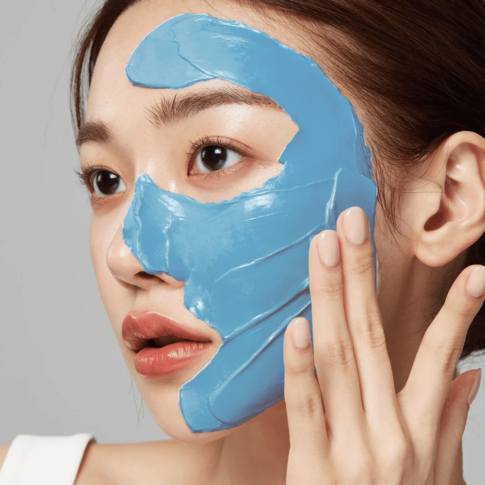 Modèle avec masque facial bleu de Medicube, couvrant la zone T pour le soin des pores.