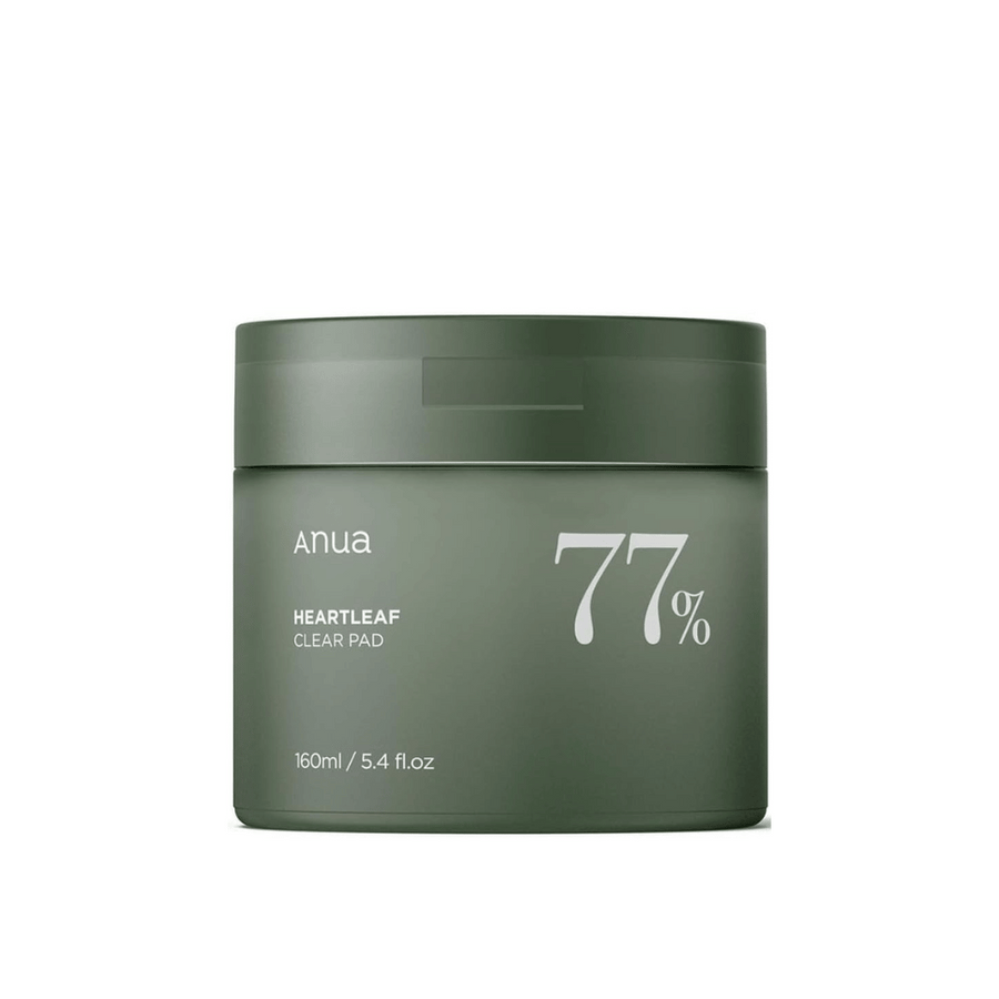 Un récipient vert avec le produit de soin de la peau Anua Heartleaf Clear Pad, mettant en avant 77% sur l'étiquette, sur un fond uni.