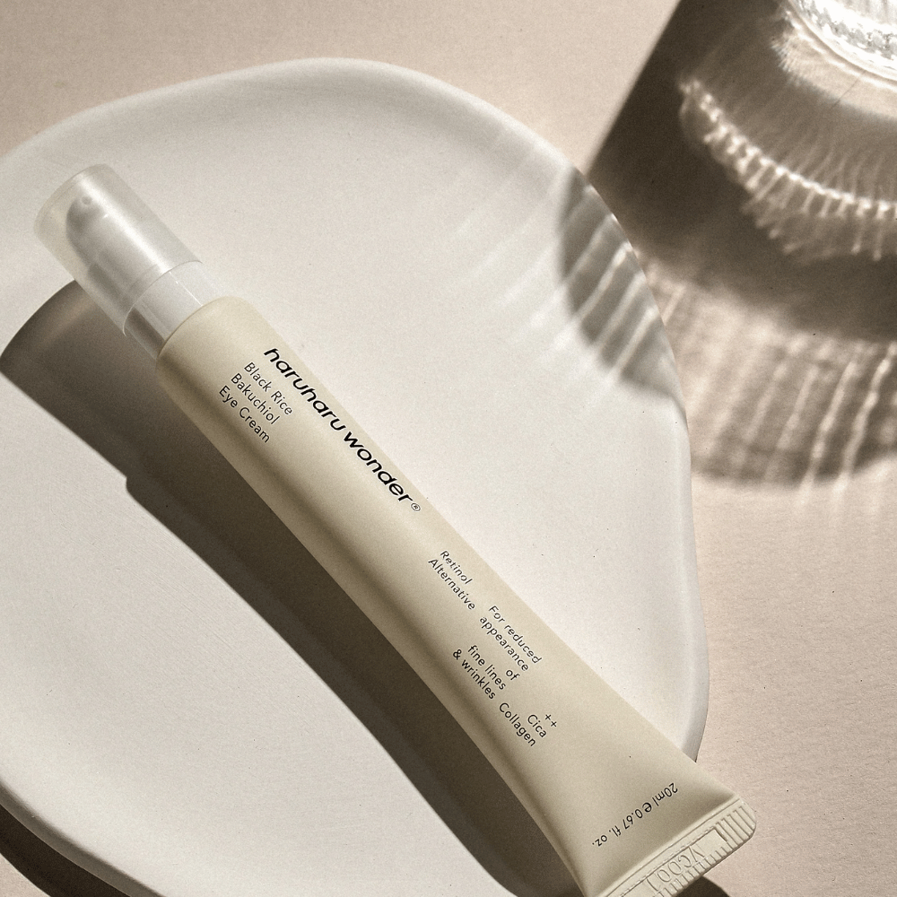 HaruHaru Wonder Black Rice Bakuchiol Eye Cream 20 ml – crème pour les yeux avec riz noir, bakuchiol et collagène qui réduit les ridules et les rides, placée sur un plat en céramique à la lumière douce.