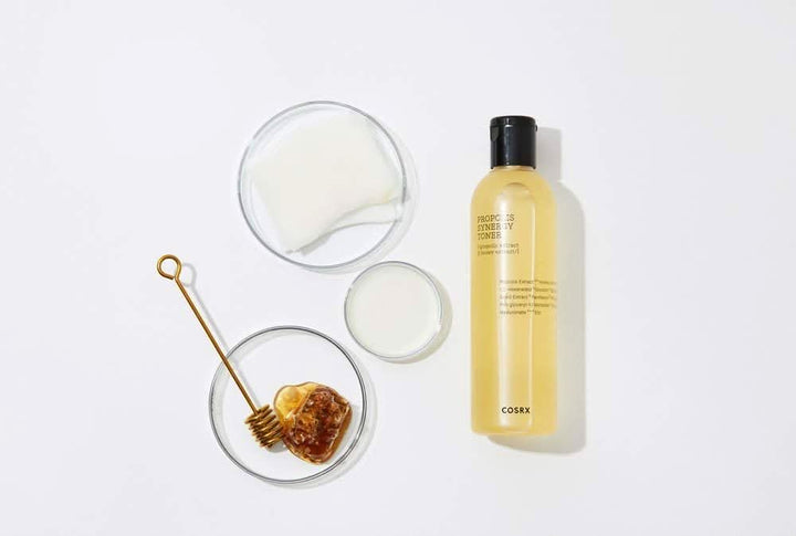 Une bouteille COSRX Full Fit Propolis Synergy Toner 150ml avec des effets anti-inflammatoires et antibactériens, posée sur une surface blanche.