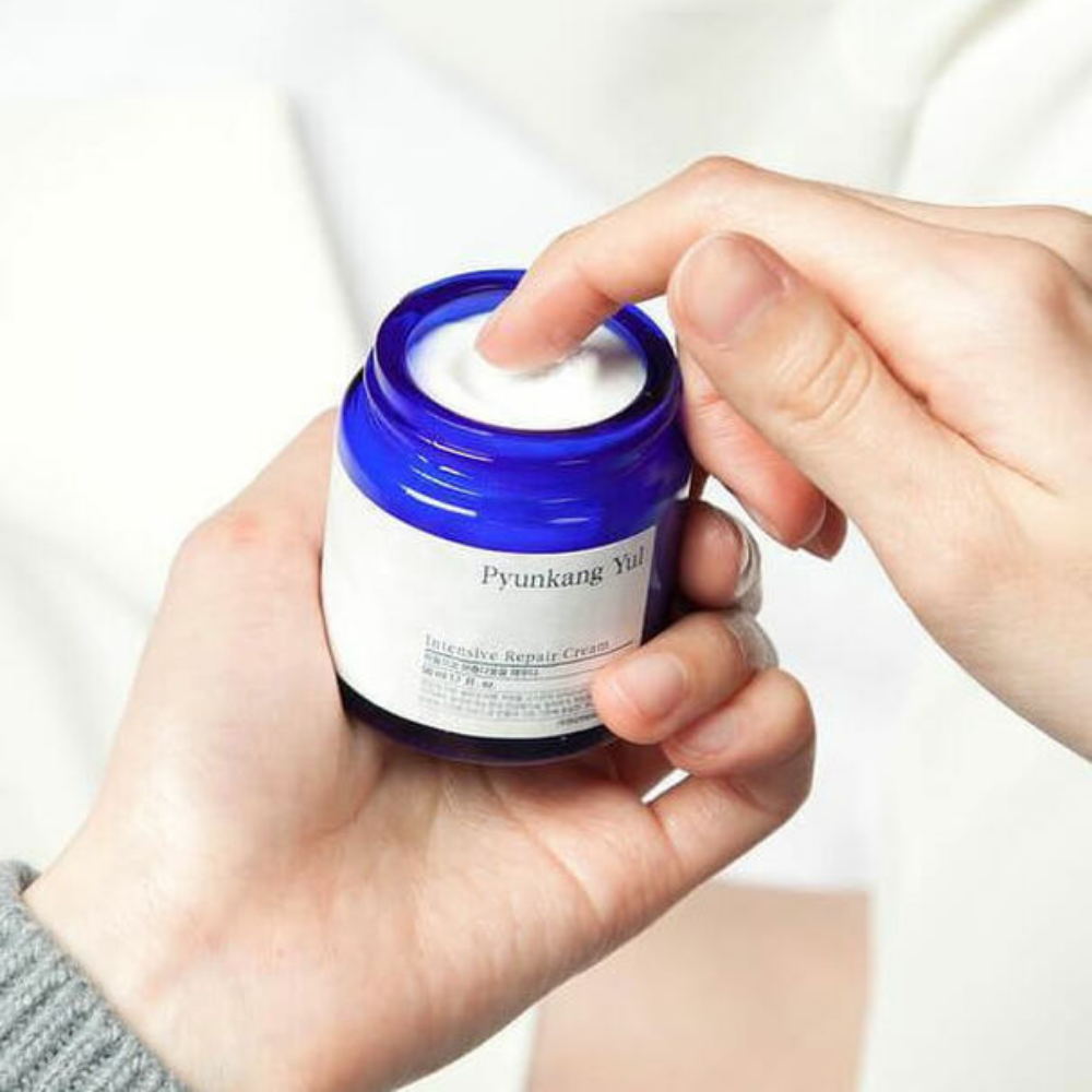Une personne tient un pot Pyunkang Yul Intensive Repair Cream 50ml.