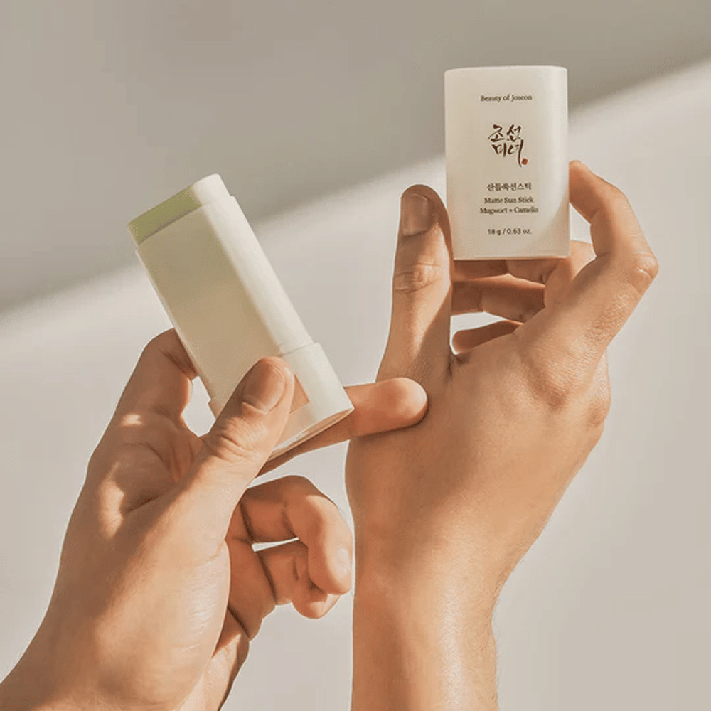 Deux mains tenant un bâton de Matte Sun Stick 18g SPF50 PA++++ de Beauty of Joseon.
