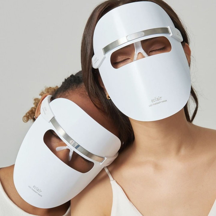 Deux femmes portant des masques blancs démontrent ECLAIR LED Therapy Mask pour les améliorations du teint de la peau.