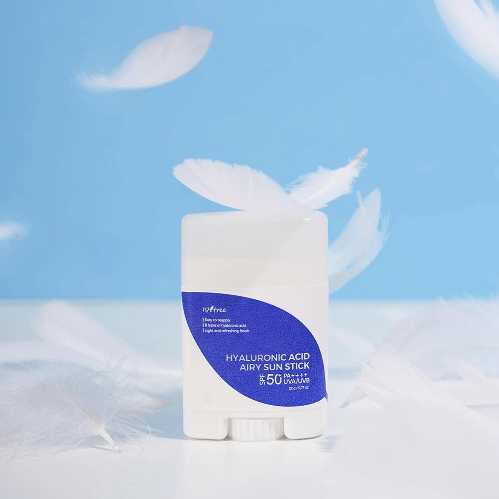 Un Isntree Hyaluronic Acid Airy Sun Stick avec SPF 50+ et de l'acide hyaluronique, orné de plumes blanches.