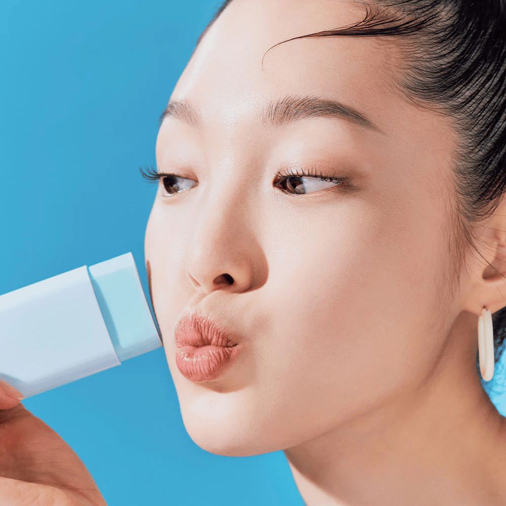 Une femme utilise un TOCOBO Cotton Soft Sun Stick SPF50+ PA++++ 19g pour nettoyer le visage.