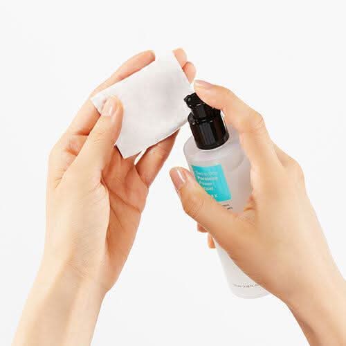 Une main montrant l'utilisation de COSRX Two In One Poreless Power Liquid 100ml pour les peaux grasses.