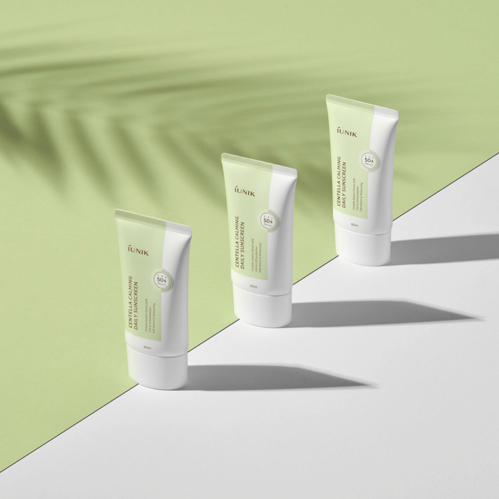Trois tubes iUNIK Centella Calming Daily Sunscreen avec SPF 50+ protection contre les rayons UVA et UVB sur fond blanc.